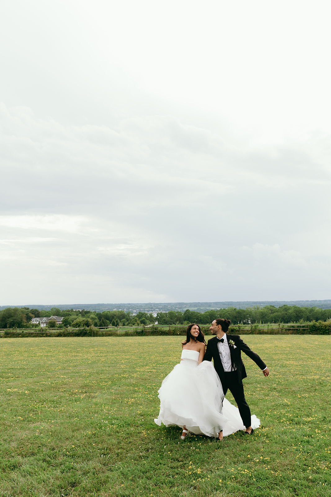 bride and groom running in the field